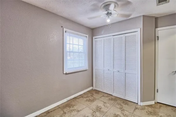 an empty room with windows and closet