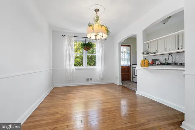 a view of a kitchen with a sink dishwasher cabinets and a chandelier