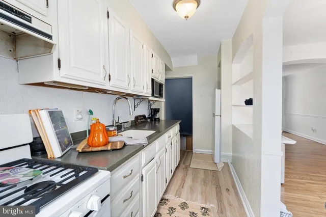 a kitchen with granite countertop white cabinets and stainless steel appliances