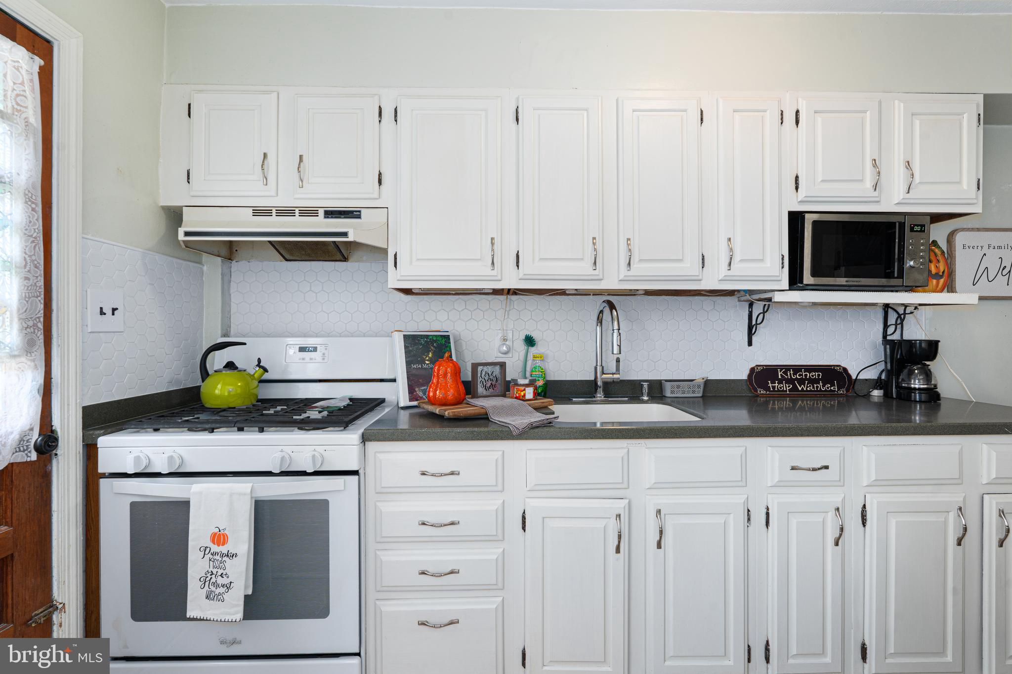 3454 McShane Way Baltimore, MD 21222 - Photo 8 of 35 a kitchen with granite countertop white cabinets and stainless steel appliances