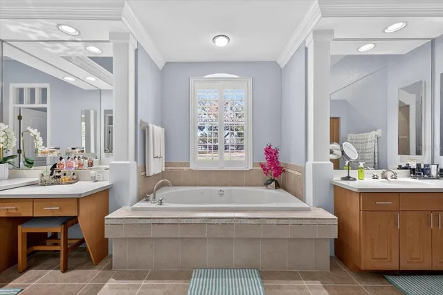 a large white kitchen with stainless steel appliances granite countertop a stove a refrigerator a sink dishwasher and wooden cabinets with wooden floor