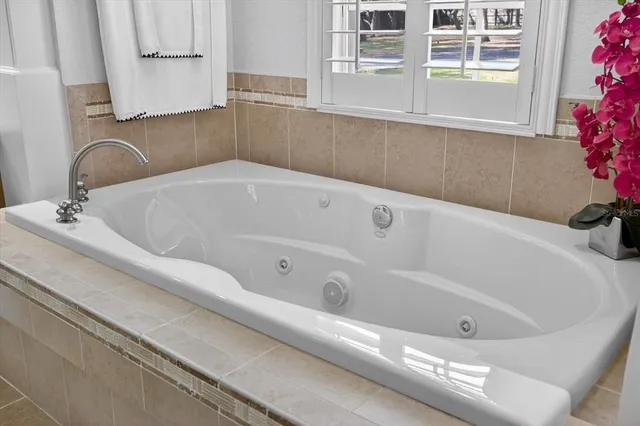 a living room with furniture a flat screen tv and large windows