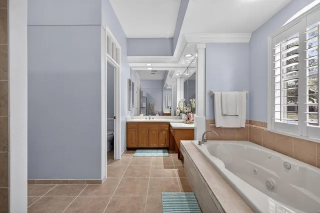 a large kitchen with stainless steel appliances granite countertop a large stove a sink dishwasher and white cabinets next to a window