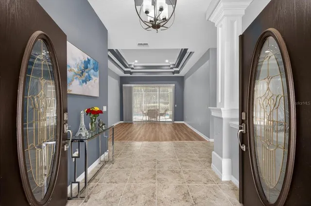 a dining room with furniture a chandelier and window