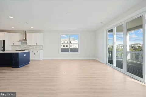 a view of kitchen with granite countertop cabinets and refrigerator