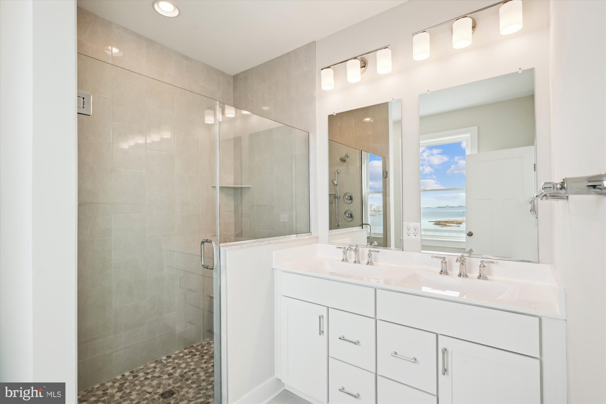 37926 Even Tide Lane Rehoboth Beach, DE 19971 - Photo 13 of 18 a bathroom with a shower sink and mirror