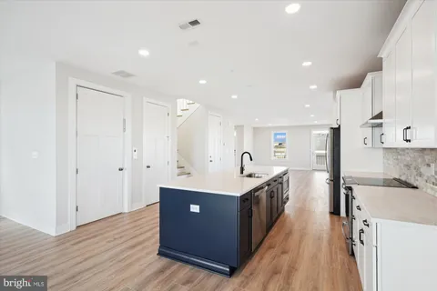 a kitchen with stainless steel appliances granite countertop a sink and a refrigerator
