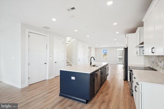 a kitchen with stainless steel appliances granite countertop a sink and a refrigerator