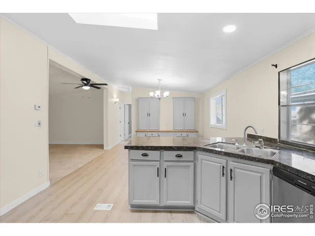 a kitchen with a sink dishwasher a refrigerator and white cabinets