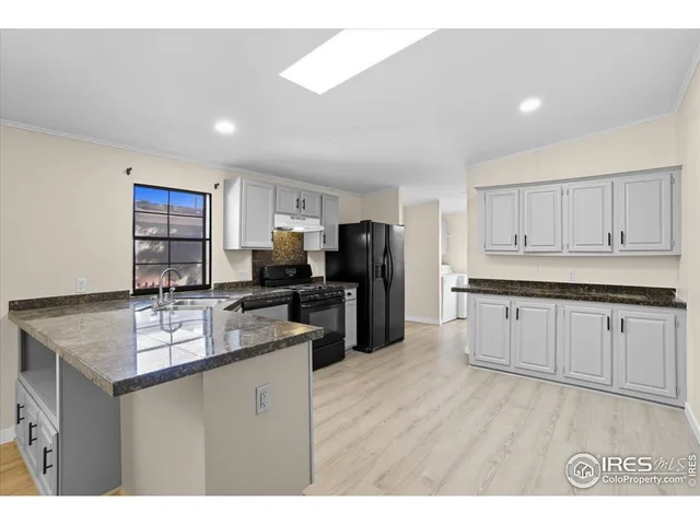 a kitchen with refrigerator cabinets and wooden floor