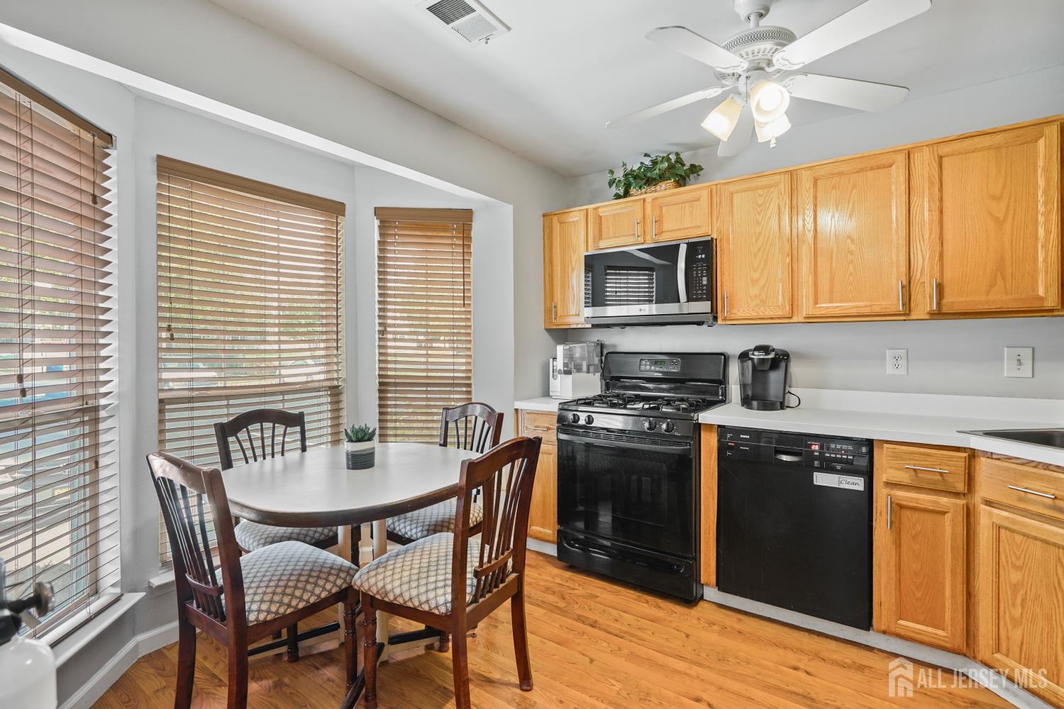 157 Setter Place Freehold, NJ 07728 - Photo 5 of 21 a kitchen with stainless steel appliances granite countertop a stove a sink dishwasher a dining table and chairs