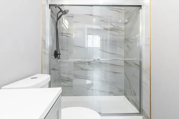 a bathroom with a shower a toilet and sink