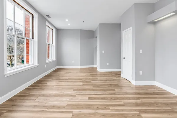 a view of a room with wooden floor and window