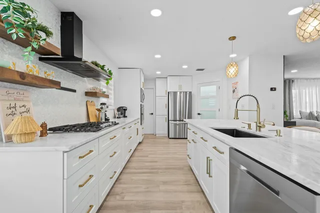 a kitchen with stainless steel appliances granite countertop a sink and cabinets with wooden floor
