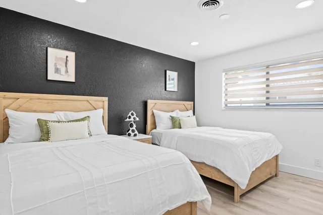 a bedroom with two beds and painting on the wall