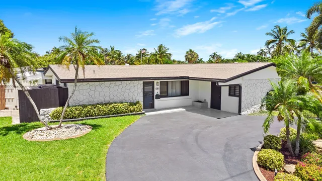a front view of a house with a garden and plants