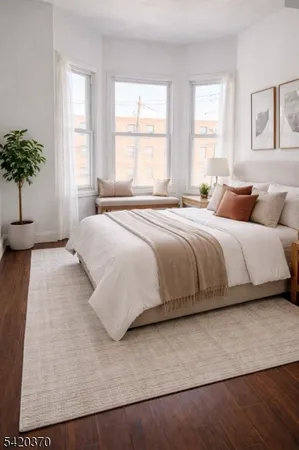 a bedroom with a large bed and a potted plant