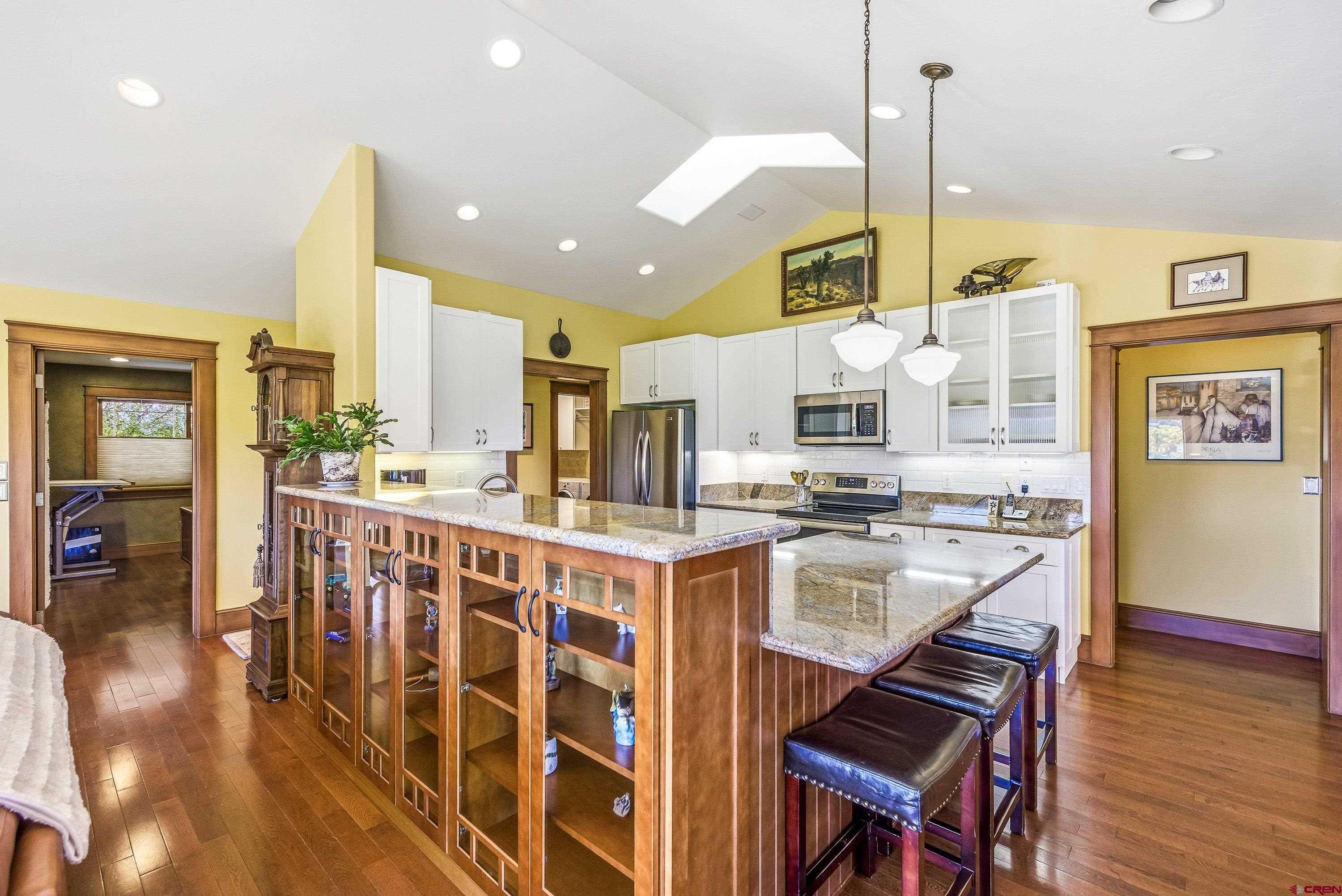 36639 M50 Road Hotchkiss, CO 81419 - Photo 20 of 45 a kitchen with stainless steel appliances kitchen island granite countertop a table chairs and a wooden floor