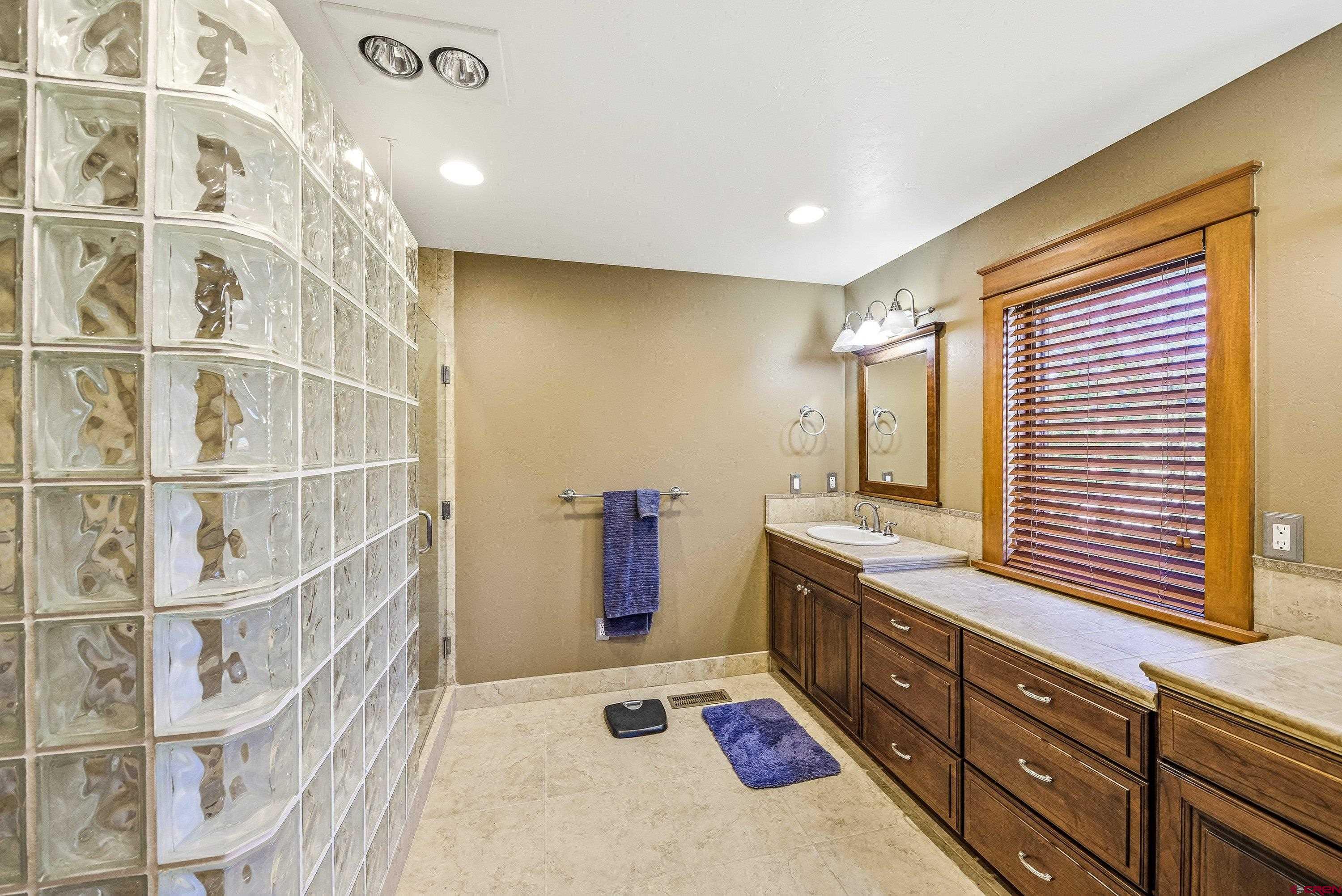 36639 M50 Road Hotchkiss, CO 81419 - Photo 29 of 45 a bathroom with a double vanity sink a mirror and a bathtub