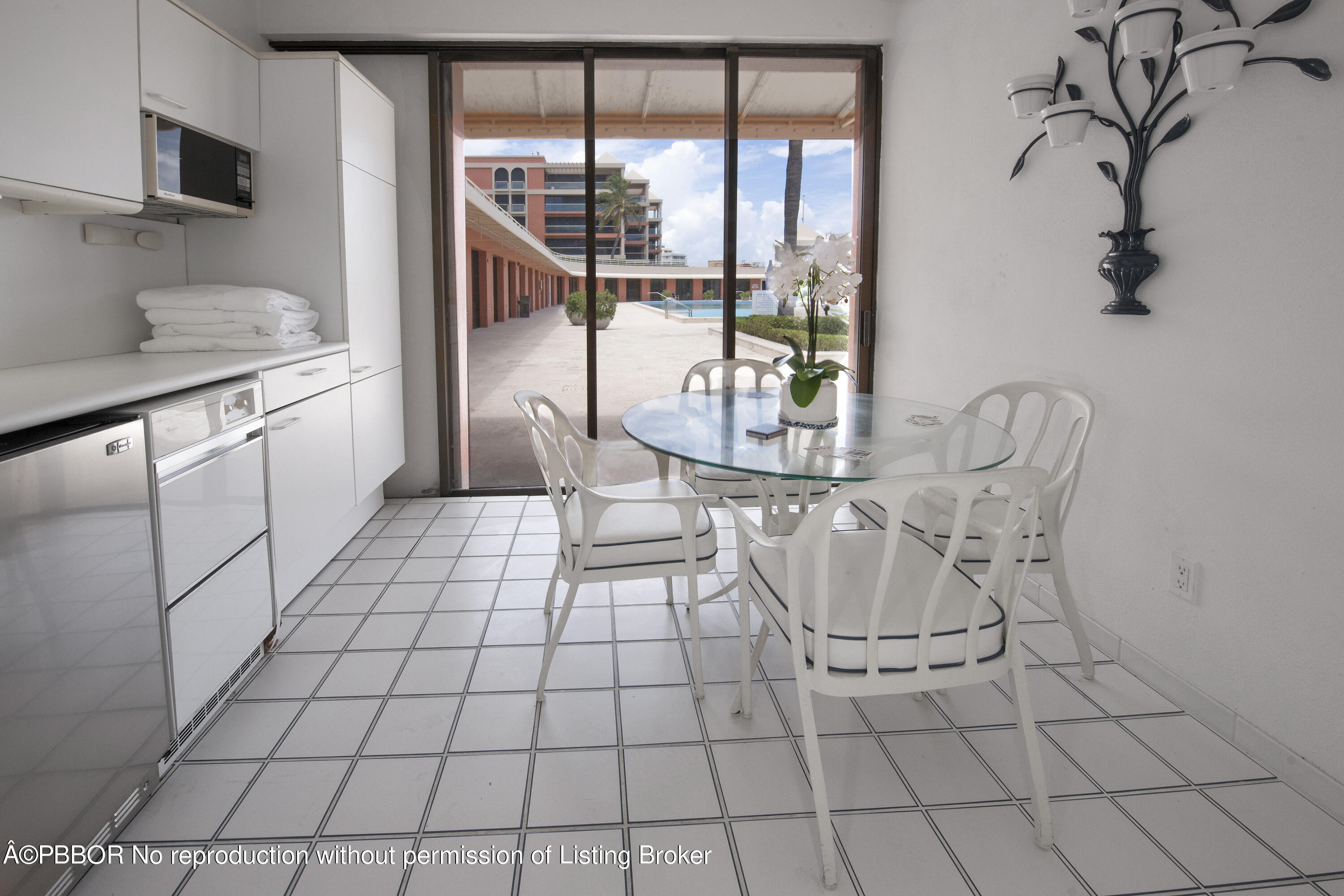 2 North Breakers Row, Unit S43 Palm Beach, FL 33480 - Photo 19 of 37 a view of a kitchen with granite countertop a stove a sink and a dining table with wooden floor