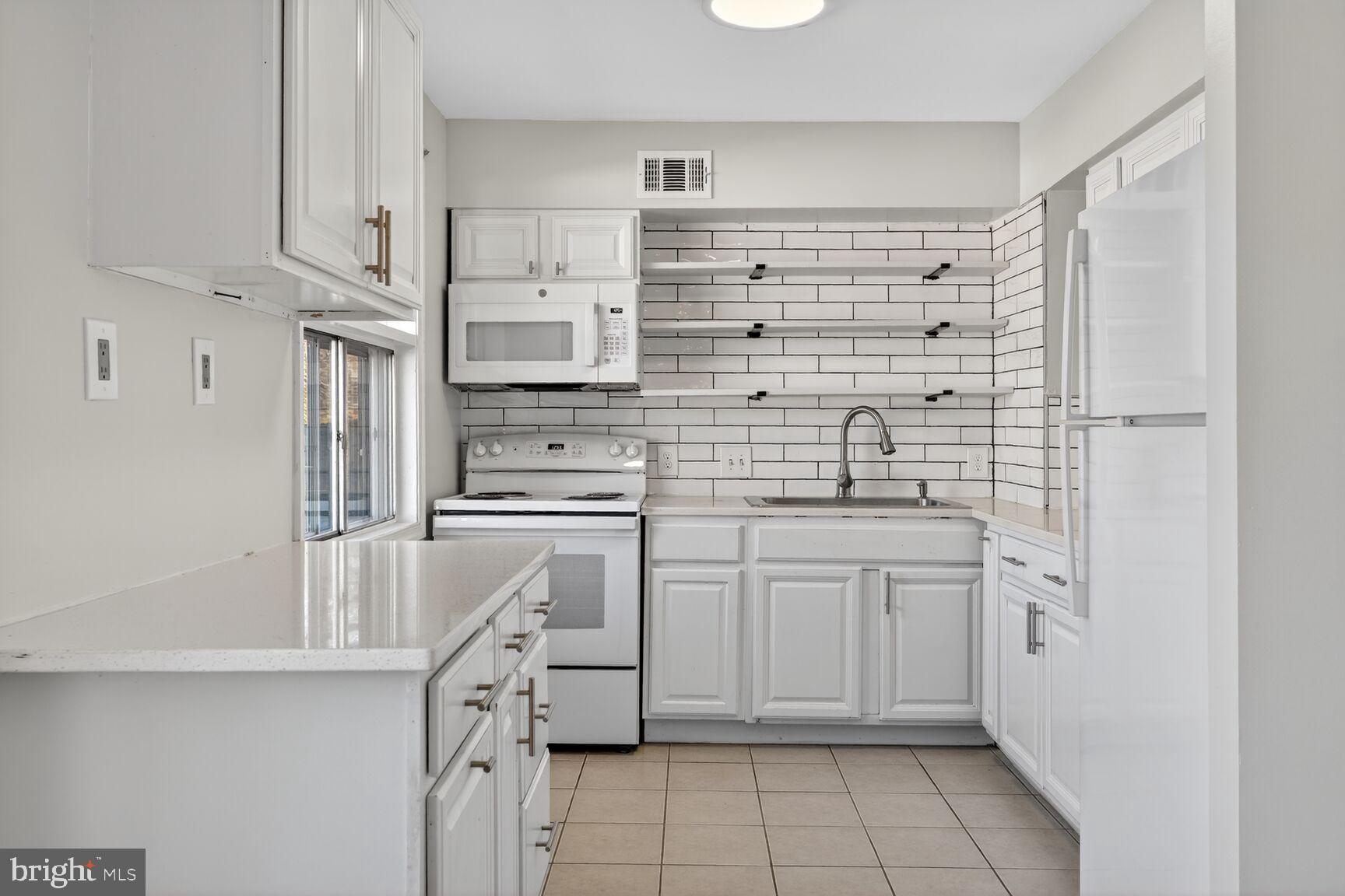 6307 Cottonwood Drive Alexandria, VA 22310 - Photo 11 of 28 a kitchen with white cabinets and white appliances