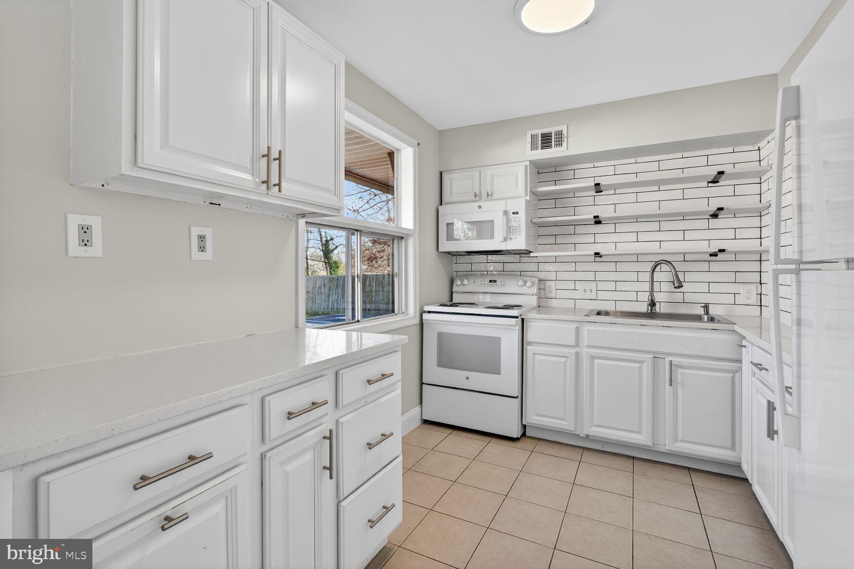 6307 Cottonwood Drive Alexandria, VA 22310 - Photo 9 of 28 a kitchen with white cabinets and white appliances