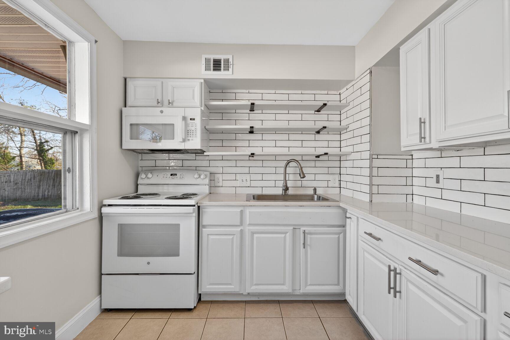 6307 Cottonwood Drive Alexandria, VA 22310 - Photo 10 of 28 a kitchen with white cabinets and white appliances