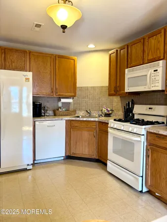 a kitchen with a refrigerator sink and cabinets