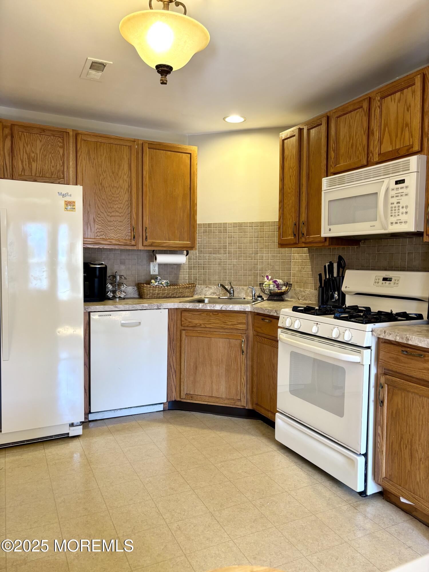 39 Rozalyn Lane, Unit 141 South Amboy, NJ 08879 - Photo 5 of 18 a kitchen with a refrigerator sink and cabinets