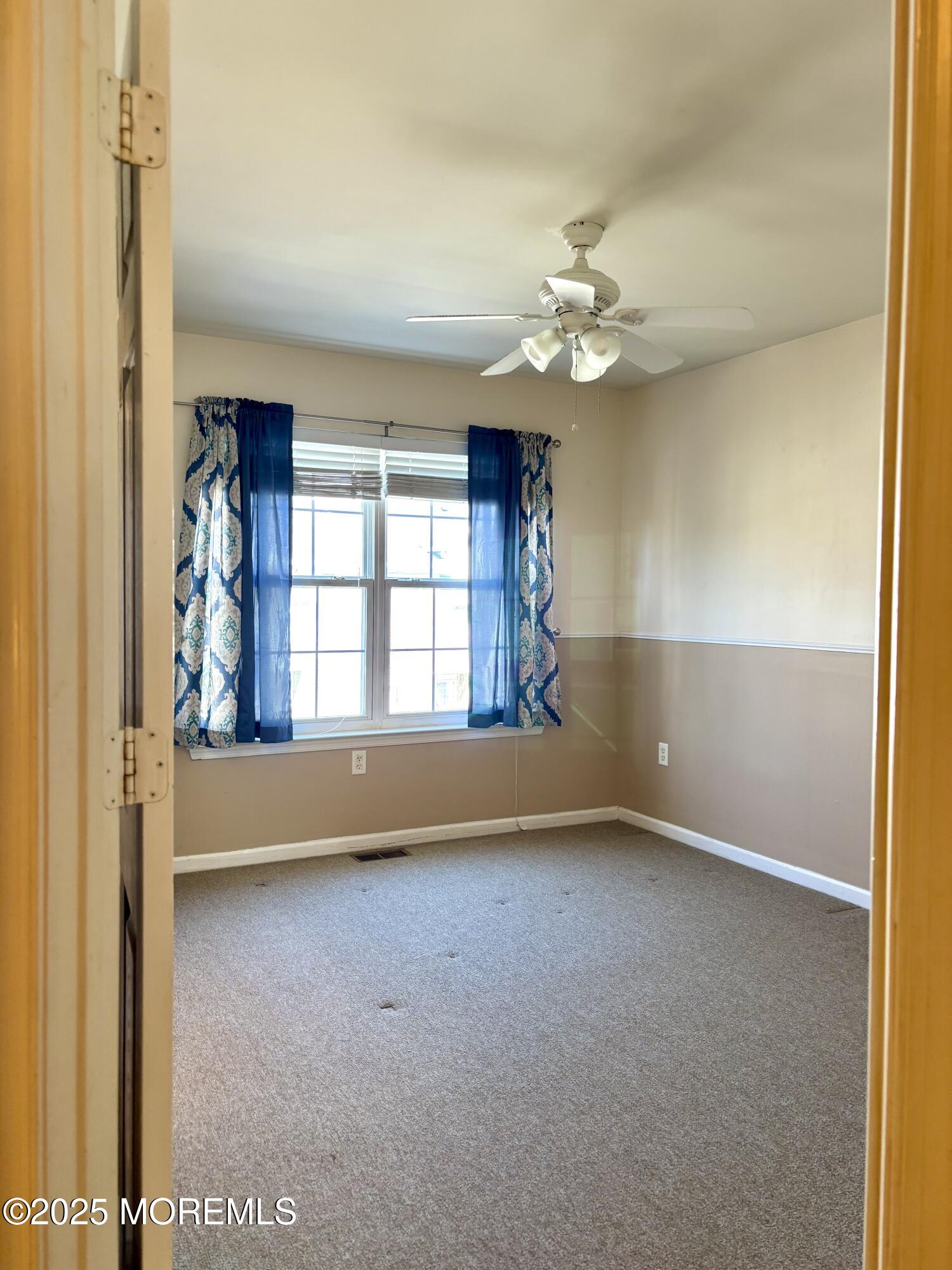 39 Rozalyn Lane, Unit 141 South Amboy, NJ 08879 - Photo 8 of 18 an empty room with windows and fan
