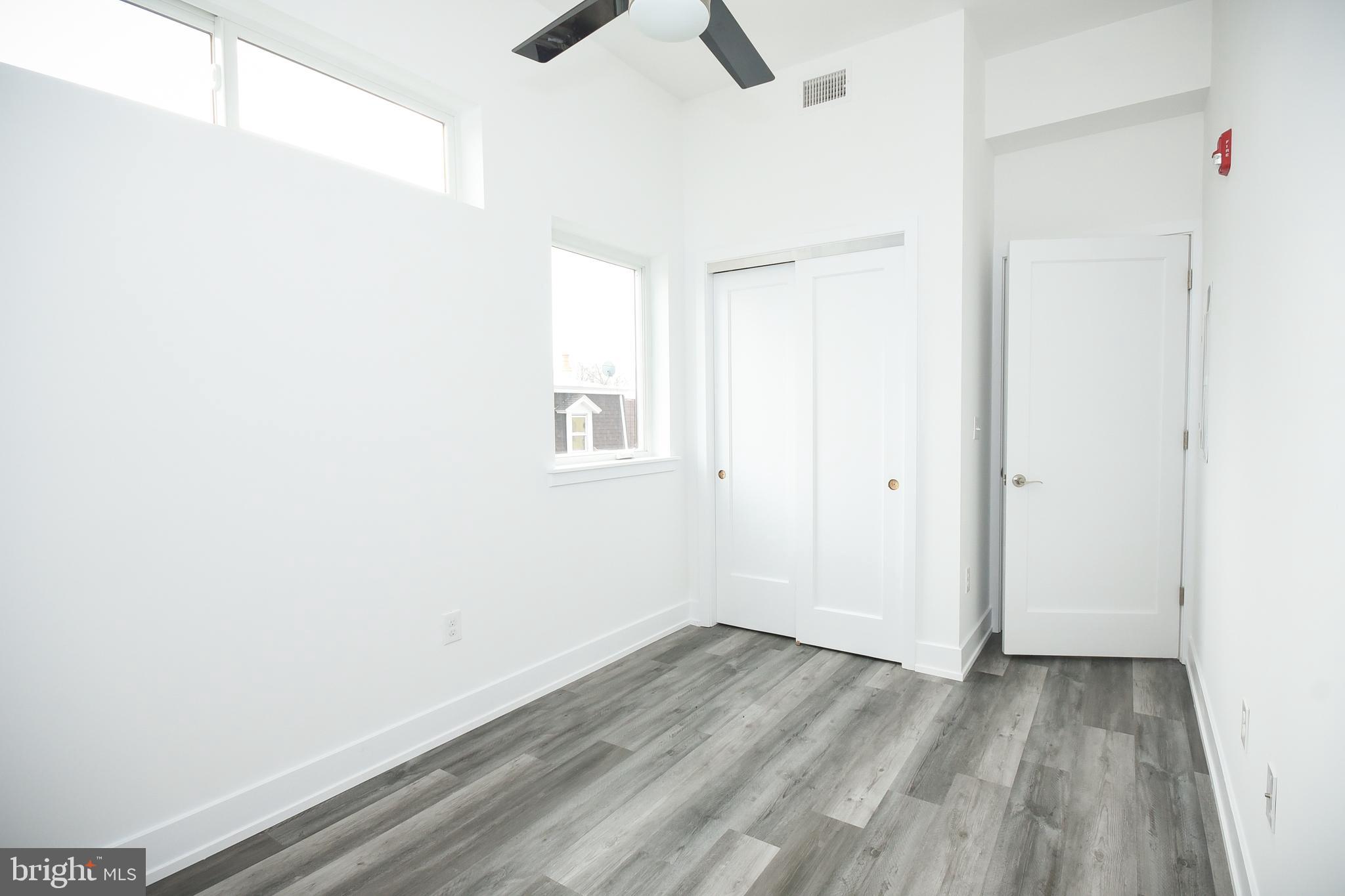 6162 Ridge Avenue, Unit 201 Philadelphia, PA 19128 - Photo 13 of 14 an empty room with a empty space and a ceiling fan