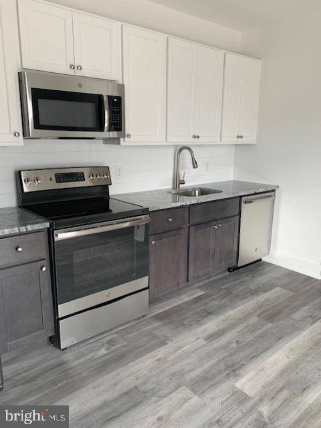 6162 Ridge Avenue, Unit 201 Philadelphia, PA 19128 - Photo 9 of 14 a kitchen with granite countertop a stove microwave and sink
