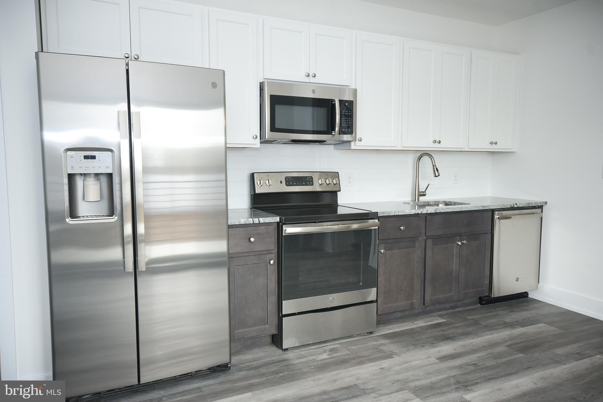 6162 Ridge Avenue, Unit 201 Philadelphia, PA 19128 - Photo 10 of 14 a kitchen with stainless steel appliances granite countertop a refrigerator a stove and a sink