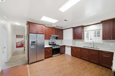 a kitchen with stainless steel appliances granite countertop a refrigerator and a sink