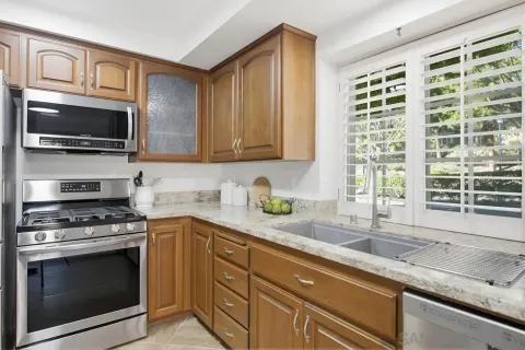 a kitchen with granite countertop a sink a stove and microwave