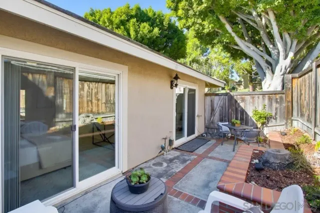 a view of a patio with table and chairs potted plants with wooden floor and fence