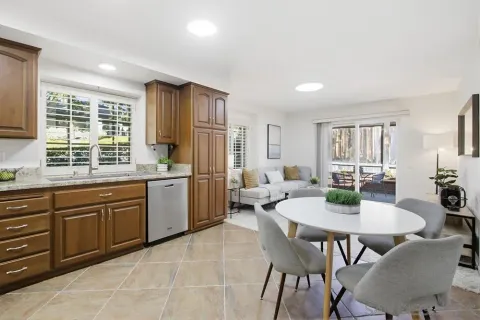 a kitchen with a dining table chairs and refrigerator