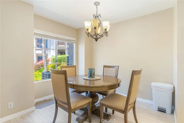 a dining room with furniture a large window and a chandelier