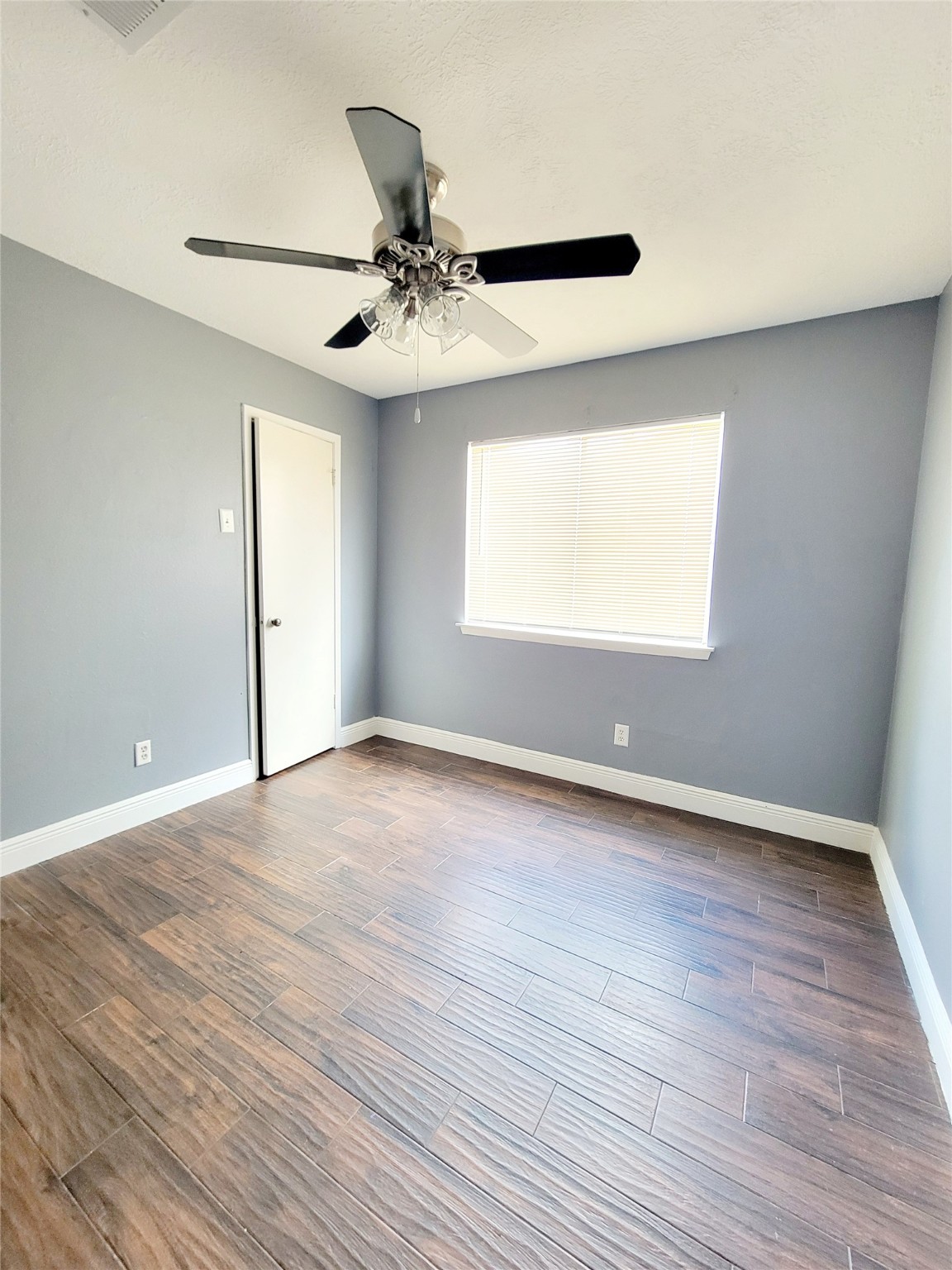 4170 Amir Street Houston, TX 77072 - Photo 7 of 10 an empty room with wooden floor fan and windows
