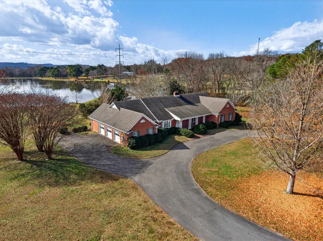 an aerial view of a house with a yard and lake view