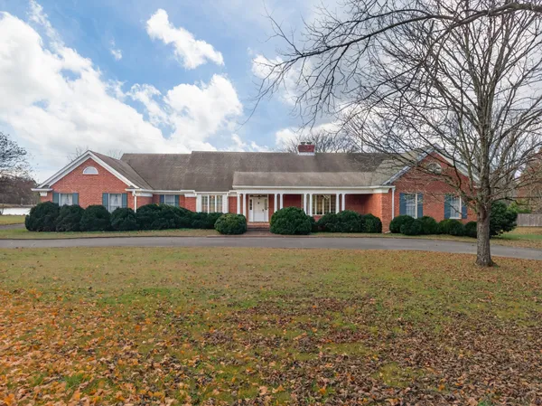 a front view of house with yard and lake
