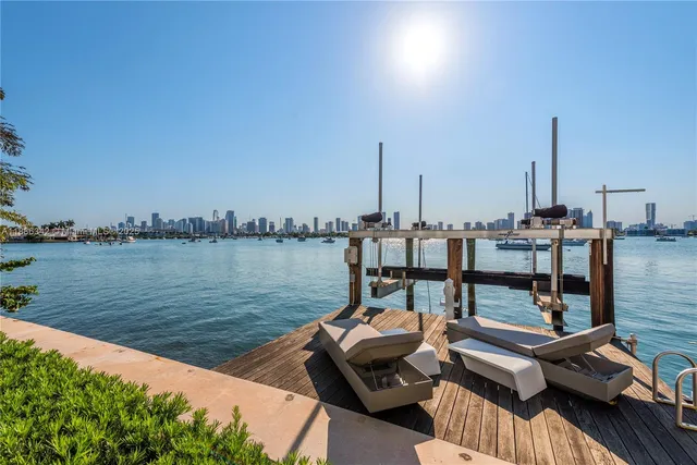 a bedroom with a bed a table and chair with wooden floor