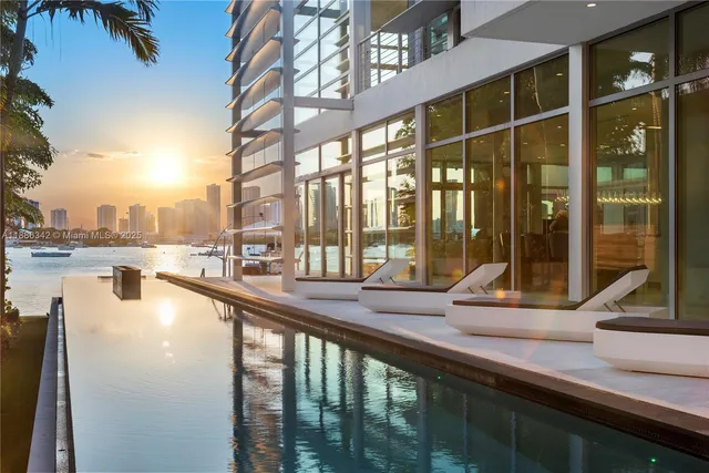 a large white kitchen with a large window and stainless steel appliances