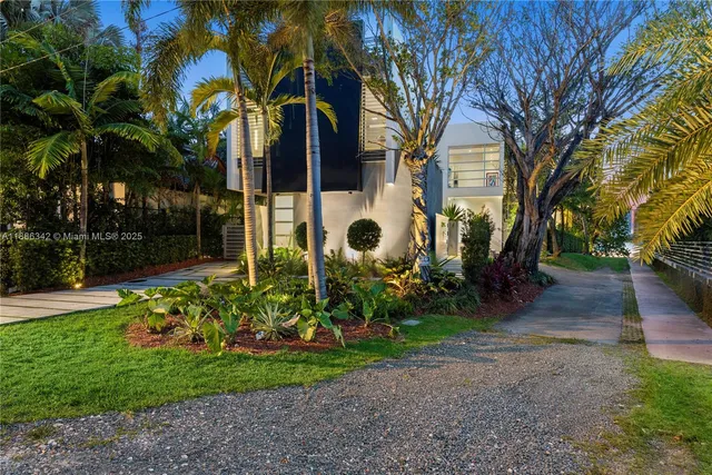 a view of a yard with plants and trees