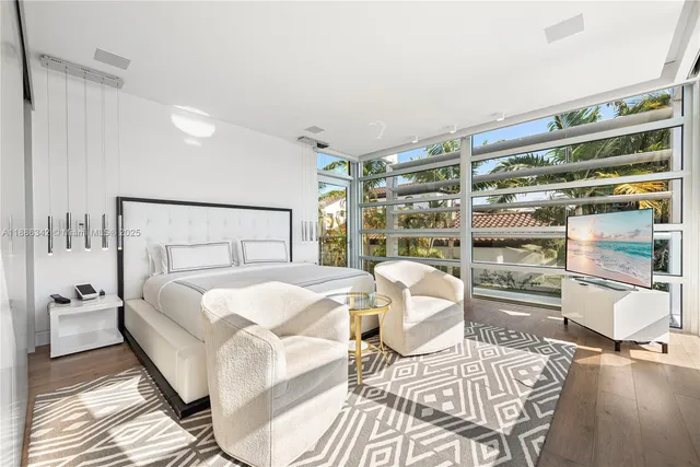 a bedroom with a bed a bookshelf and a large window