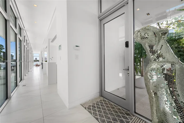 a living room with furniture a floor to ceiling window and kitchen view