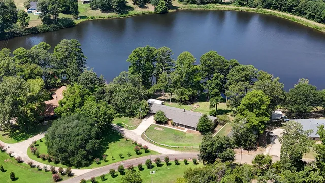 an aerial view of a house with a yard and lake view