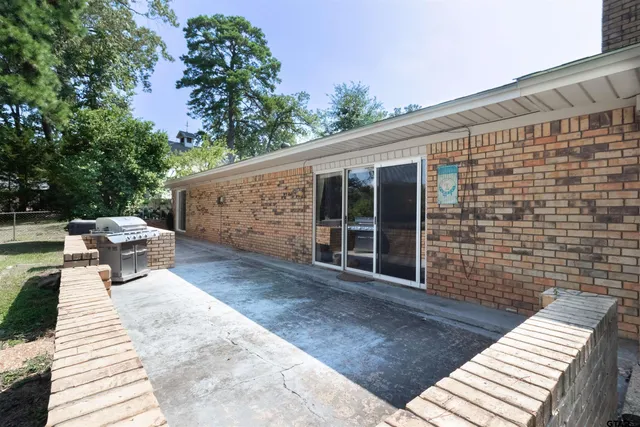 a view of a patio with table and chairs with wooden floor and fence