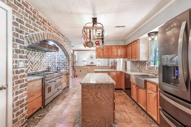 a kitchen with stainless steel appliances granite countertop a stove and cabinets