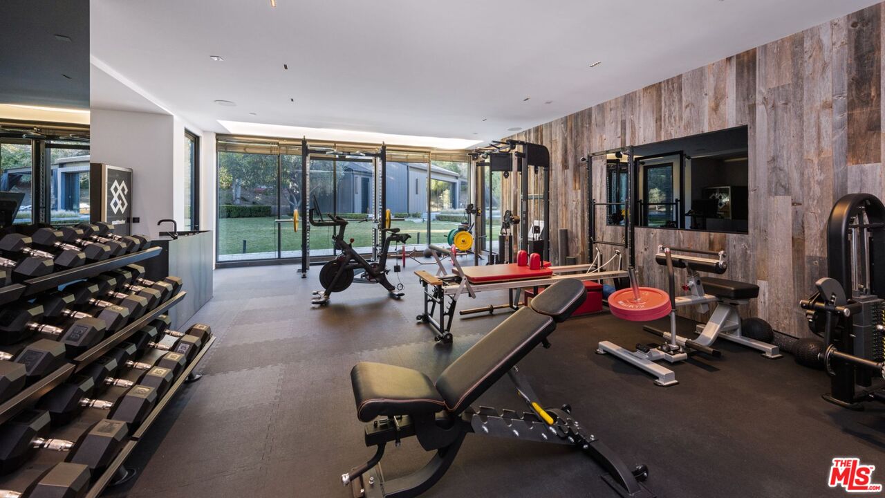 24350 Bridle Trail Road Hidden Hills, CA 91302 - Photo 12 of 23 a living room with lots of furniture and gym equipment